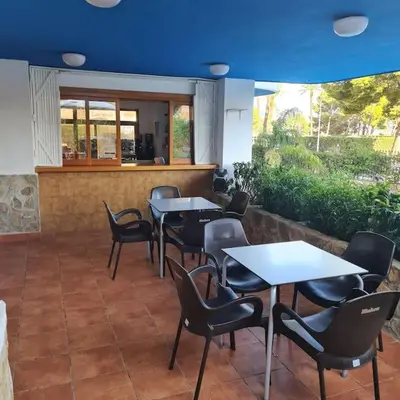 a row of tables and chairs in a restaurant at Precioso apartamento en Cullera, con piscina junto a la playa in Cullera