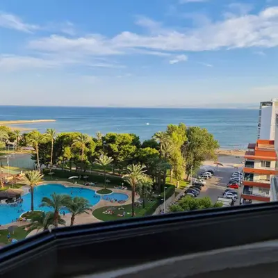 a view of a resort with a pool and the ocean at Precioso apartamento en Cullera, con piscina junto a la playa in Cullera