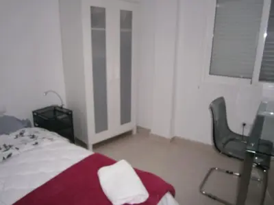 a white room with a bed and a window at Apartamento junto a playa y cerca de campo de golf in El Perellonet