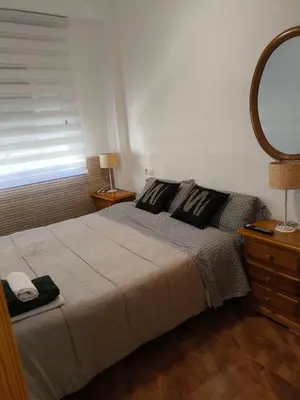 a bedroom with a large bed and a mirror at Apartamento en la playa in Tavernes de Valldigna