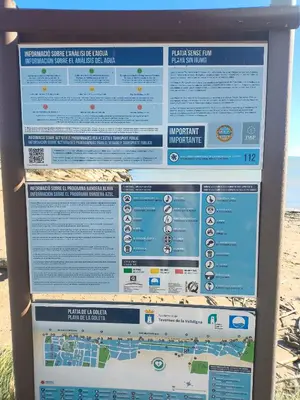 a sign at the beach with a map at Apartamento en la playa in Tavernes de Valldigna
