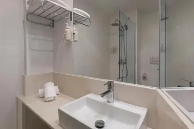 a white bathroom with a sink and a mirror at B&B HOTEL Valencia Arena in Valencia