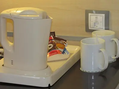 a white tea kettle and two cups on a counter at Holiday Inn Express Valencia Bonaire by IHG in Aldaya