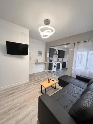 a living room with a black couch and a table at Apartamento Sofía II a 500m de la playa in Puerto de Sagunto