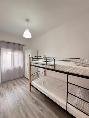 two bunk beds in a room with a window at Apartamento Sofía II a 500m de la playa in Puerto de Sagunto