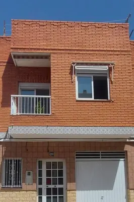 a brick building with two windows and a white garage at Apartamento Sofía II a 500m de la playa in Puerto de Sagunto