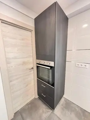 a small kitchen with a microwave and a closet at Apartamento Sofía II a 500m de la playa in Puerto de Sagunto