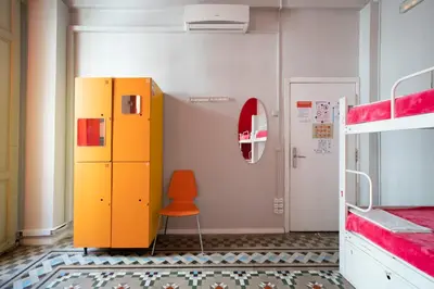 a room with a yellow locker and a orange chair at Red Nest Hostel in Valencia