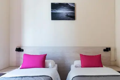 two beds in a room with pink pillows at Red Nest Hostel in Valencia