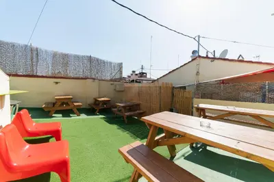 a patio with picnic tables and red chairs at Red Nest Hostel in Valencia