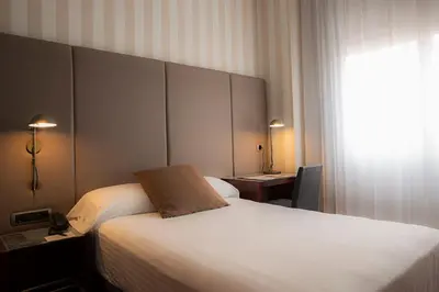 a hotel room with a large bed and a window at Zenit Valencia in Valencia