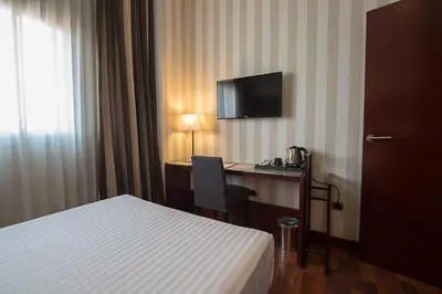 a hotel room with a bed and a desk and a television at Zenit Valencia in Valencia