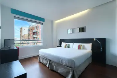 a bedroom with a large bed and a window at Sea You Hotel Port Valencia in Valencia