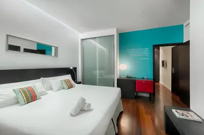 a bedroom with a white bed and a blue wall at Sea You Hotel Port Valencia in Valencia