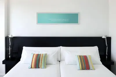 a bed with white pillows and a black headboard at Sea You Hotel Port Valencia in Valencia