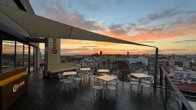 a group of tables and chairs on a balcony with a sunset at Sea You Hotel Port Valencia in Valencia