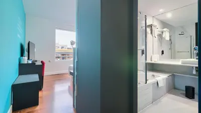 a bathroom with a sink and a large mirror at Sea You Hotel Port Valencia in Valencia