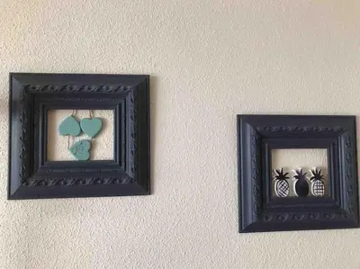two pictures of hearts and vases on a wall at The Beach Apartment in El Puig