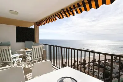 a balcony with chairs and a view of the ocean at The Beach Apartment in El Puig