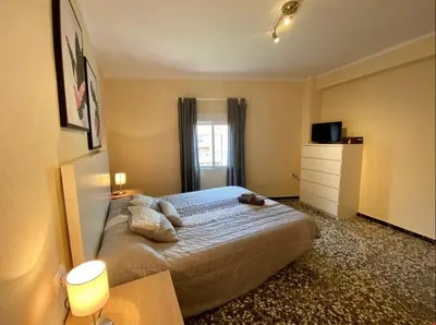 a bedroom with a bed and a dresser and a window at Las Peñetas in Bolbaite
