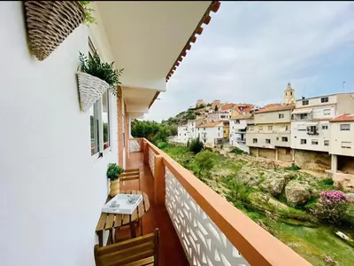 a balcony with a table and chairs and buildings at Las Peñetas in Bolbaite