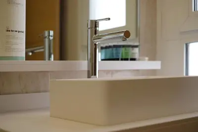 a bathroom sink with a faucet in front of a mirror at Hotel Mediterraneo Valencia in Valencia