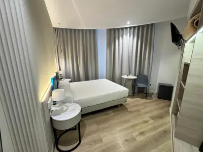 a bedroom with a bed and a table and a chair at Hotel Mediterraneo Valencia in Valencia