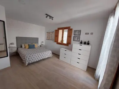 a bedroom with a bed and a dresser and a window at Ca La Abuela in Requena