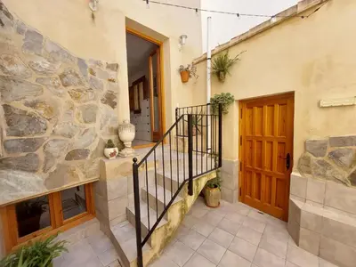 a stone building with a staircase and a door at Ca La Abuela in Requena
