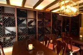 a dining room with a table and a wall of wine bottles at Hotel Rioja in Benisanó
