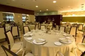 a dining room with a white table and chairs at Hotel Rioja in Benisanó