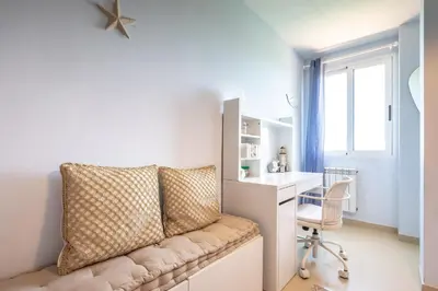 a room with a couch and a desk and a window at Casa junto al mar con jardín in Sagunto