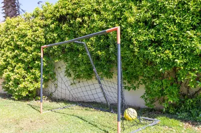 a soccer goal with a ball in front of a bush at Casa junto al mar con jardín in Sagunto