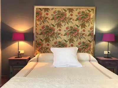 a bedroom with a bed with two lamps on two tables at Hotel Patilla Ciudad de Requena in Requena