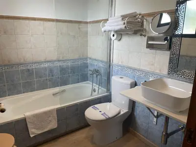 a bathroom with a tub and a toilet and a sink at Hotel Patilla Ciudad de Requena in Requena
