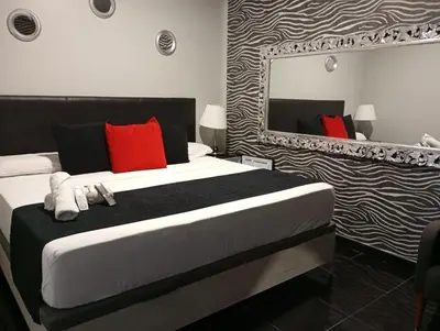 a bedroom with a bed with red pillows and a mirror at Apartamentos Rous - Solo adultos in Valencia