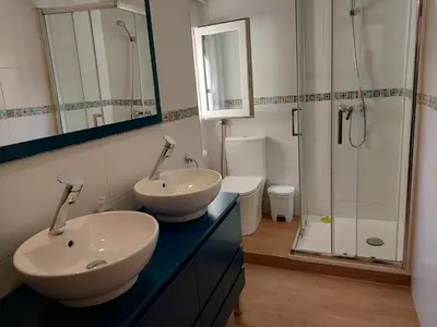 a bathroom with two sinks and a shower at Apartamentos Rous - Solo adultos in Valencia