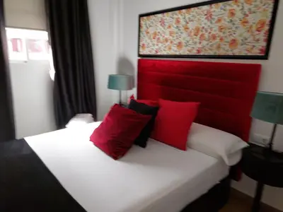 a bedroom with a red and white bed with red pillows at Apartamentos Rous - Solo adultos in Valencia