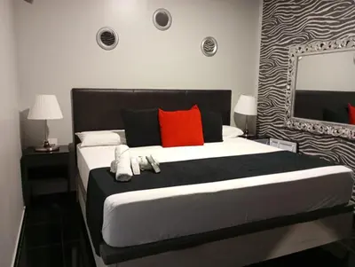 a bedroom with a large bed with red pillows and a mirror at Apartamentos Rous - Solo adultos in Valencia