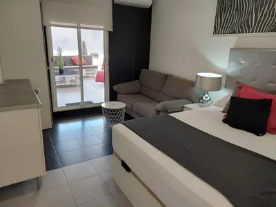 a bedroom with a bed and a living room with a couch at Apartamentos Rous - Solo adultos in Valencia