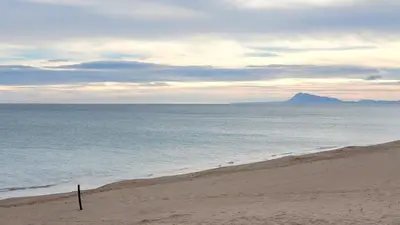 a beach with a view of the ocean and a mountain at appartement pied dans l eau in El Brosquil