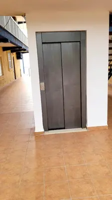 a large metal door in a building with a tile floor at appartement pied dans l eau in El Brosquil