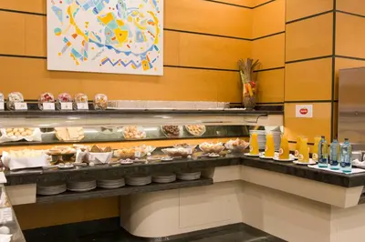 a buffet line with plates of food in a restaurant at Aparthotel Albufera in Alfafar