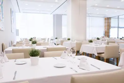 a dining room with white tables and chairs at Aparthotel Albufera in Alfafar