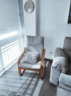 a chair in a room with a clock on the wall at Precioso apartamento en el Faro de Cullera in Cullera