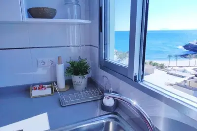 a kitchen sink with a window with a view of the ocean at Precioso apartamento en el Faro de Cullera in Cullera