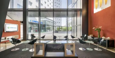 a lobby with a glass table and chairs in a building at Ilunion Aqua 3 in Valencia