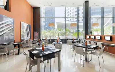 a restaurant with tables and chairs and large windows at Ilunion Aqua 3 in Valencia