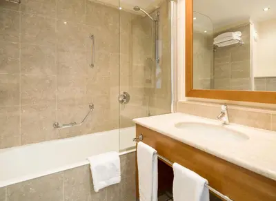 a bathroom with a sink and a shower with a mirror at Ilunion Aqua 3 in Valencia