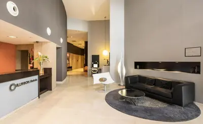 a living room with a black couch and a table at Ilunion Aqua 3 in Valencia